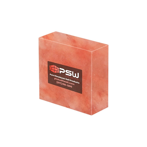A rectangular block of pinkish-orange Himalayan salt with a black and red PSW brand label on the front, set against a plain light gray background.